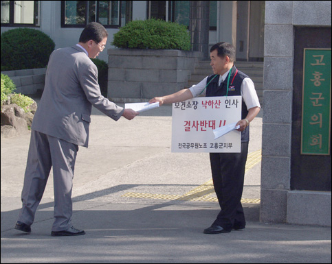 군청에 출근하는 직원들에게 유인물 배포 